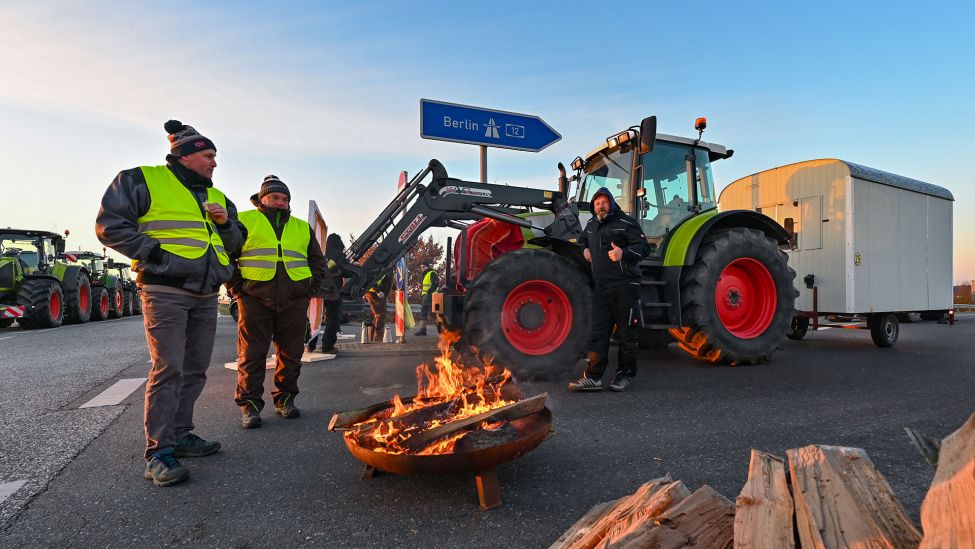 08.01.2024, Brandenburg, Jacobsdorf: Landwirte blockieren am frühen Morgen mit einem Traktor die Auffahrt auf die Autobahn A12 in Richtung Berlin.(Quelle:picture alliance/dpa/P.Pleul)