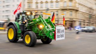 Ein Traktor mit «Wir sind das Volk»-Plakat fährt bei einem Protest mit Traktorkorso des Landesbauernverbands Brandenburg gegen die Erhöhung der Steuer auf Agrardiesel von der Bundesgeschäftsstelle von Bündnis90/DieGrünen zur Bundesgeschäftsstelle der FDP.