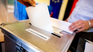 Archivbild: Ein Wähler wirft in einem Wahllokal, das im Klassenraum einer Grundschule im Stadtteil Prenzlauer Berg untergebracht ist, seinen Stimmzettel für die Bundestagswahl in eine Wahlurne. (Quelle: dpa/Dittrich)