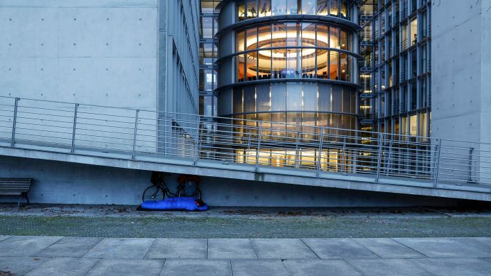 In einem Schlafsack schläft am 0.11.2023 ein Obdachloser am Paul Loebe Haus in Berlin. (Quelle: Picture Alliance/Jochen Eckel)