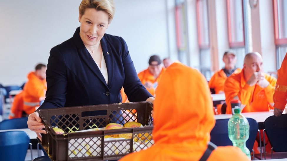 Franziska Giffey (SPD), Berliner Senatorin für Wirthschaft, bietet am 31.12.2023 den Mitarbeitern der BSR Pfannkuchen an, während sie die Berliner Stadtreinigung besucht. (Quelle: dpa-Bildfunk/Annette Riedl)