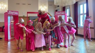 Männer in pinken Barbie-Kostümen posieren in einem Festsaal. (Quelle: rbb)