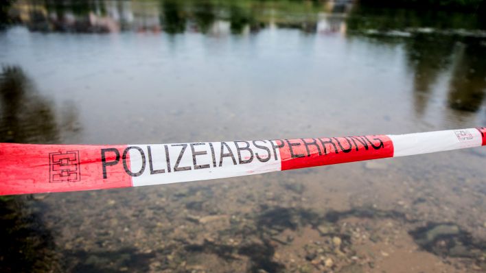 Symbolbild: Wasserleiche im Fluss oder Kanal mit Absperrband der Polizei. (Quelle: dpa/K.Schmitt)