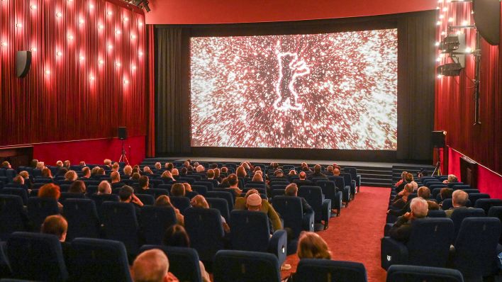 Archivbild: Kinobesucher sitzen während der 72. Internationalen Filmfestspiele am 13.02.2022 im Kinosaal vom Delphi-Filmpalast in Berlin. (Quelle: dpa-Zentralbild/Jens Kalaene)