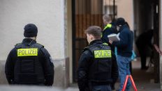 Polizeibeamte und Kriminaltechniker stehen am Morgen des 20.02.2024 vor einem Haus an der Koloniestraße in Berlin-Gesundbrunnen. (Quelle: dpa-Bildfunk/Paul Zinken)