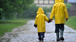 Symbolbild:Zwei Kinder gehen in Regensachen und Gummistiefeln durch das brandenburgischen Sieversdorf (Oder-Spree).(Quelle:picture alliance/dpa-Zentralbild/P.Pleul)