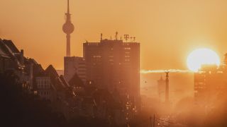 Symbolbild: Die Siegessaeule und der Fernsehturm zeichnen sich ab vor der aufgehenden Sonne in Berlin. (Quelle: dpa/Gaertner)