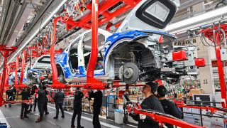 Mitarbeiter der Tesla Gigafactory Berlin Brandenburg arbeiten am 22.03.2022 an einer Fertigungslinie eines Elektrofahrzeuges vom Typ Model Y. (Quelle: dpa/Patrick Pleul)