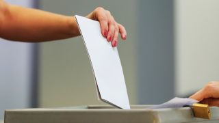 Symbolbild: Eine Wählerin wirft bei der Stimmabgabe den Wahlzettel in einem Wahllokal in eine Wahlurne. (Quelle: dpa/Robert Michael)