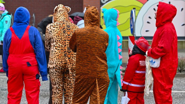 Symbolbild: Kostümierte Teilnehmer warten am 11.02.2024 am Straßenrand auf den Beginn des Karnevalumzugs in Cottbus, Brandenburg. (Quelle: dpa/Patrick Pleul)