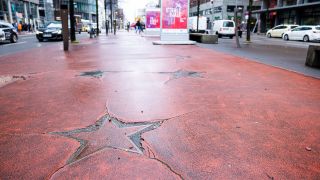 Boulevard der Stars Deutschland, Berlin im Februar 2024: Eine polierte Bronzesternspitze umgeben von sehr verwittertem rot-gefäbten Asphalt auf dem Mittelstreifen der Potsdamer Straße. (Quelle: Imago Images/Achille Abboud)