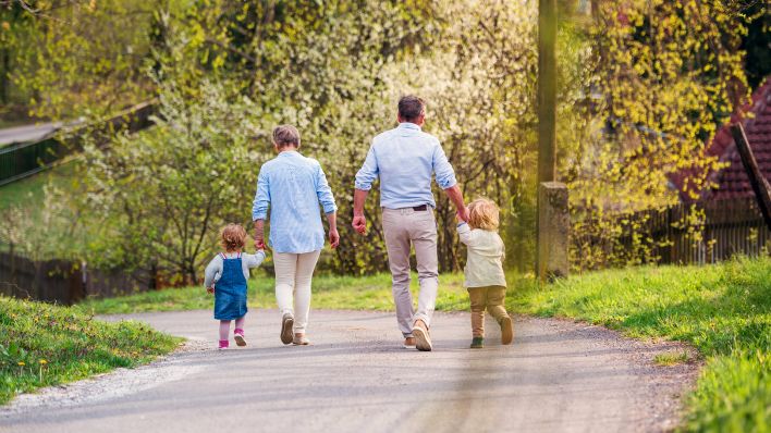 Symbolbild: Großeltern spazieren mit ihren Enkelkindern. (Quelle: IMAGO/HalfPoint Images)