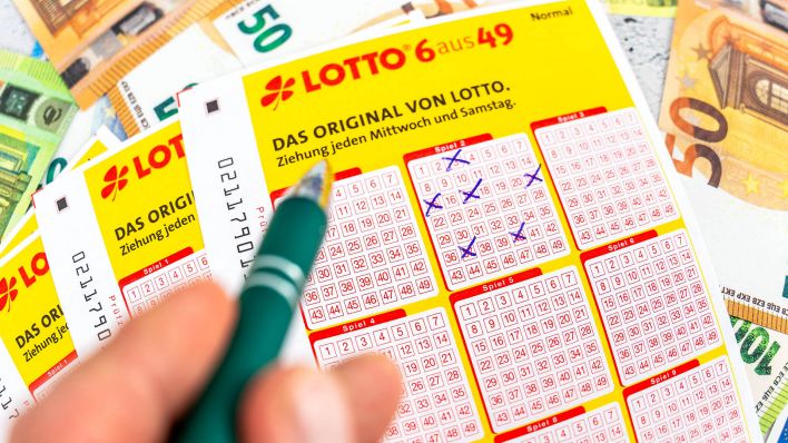 Symbolbild: Eine Person füllt einen Lottoschein aus. (Quelle: imago images/bihlmayer)