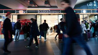 Archivbild vom 21.04.2023: Menschen gehen am Reisezentrum auf dem Berliner Hauptbahnhof vorüber bzw. hinein (Quelle: dpa / Annette Riedl).