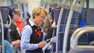 Symbolbild: Eine Zugbegleiterin kontrolliert in einem Regionalzug die Fahrkarten der Reisenden am 05.04.2017 in Magdeburg Tickets.(Quelle: picture alliance/Peter Gercke)