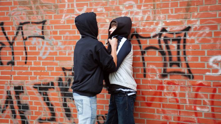 Symbolbild: Ein Teenager drückt einen Jungen gewaltsam gegen eine Wand, gestellte Szene. (Quelle: dpa/Siegfried Kuttig)