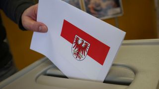 Symbolbild: Kommunalwahlen in Brandenburg. Ein Mann legt seinen Wahlschein in eine Wahlurne. (Quelle: dpa/Baumgarten)