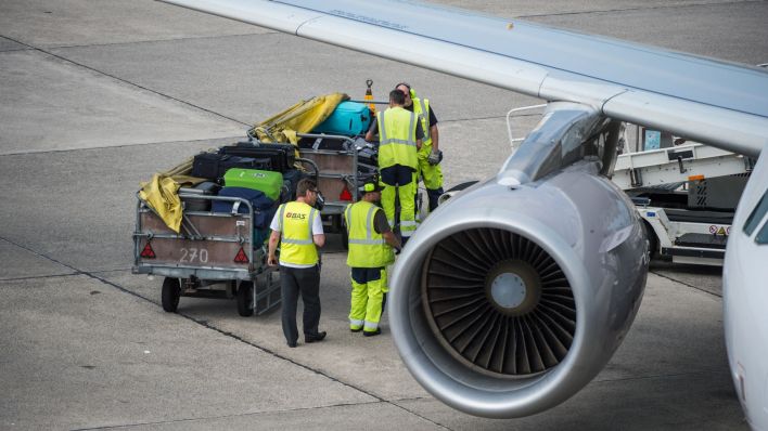 Mitarbeiter des Bodenpersonals beladen eine Lufthansa-Maschine. Foto: Arne Immanuel Bänsch/dpa