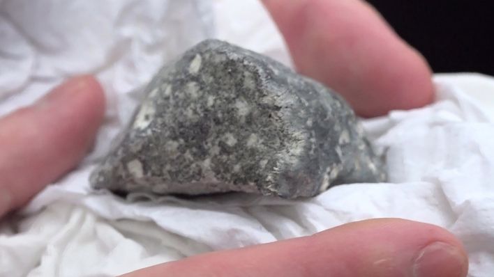 Archivbild: Ein mutmaßliches Meteoritenteil liegt in einem Papiertaschentuch. Das Bruchstück wurde von vier polnischen Meteortitensuchern auf einem Feld bei Ribbeck gefunden. (Quelle: dpa/Dettlaff)