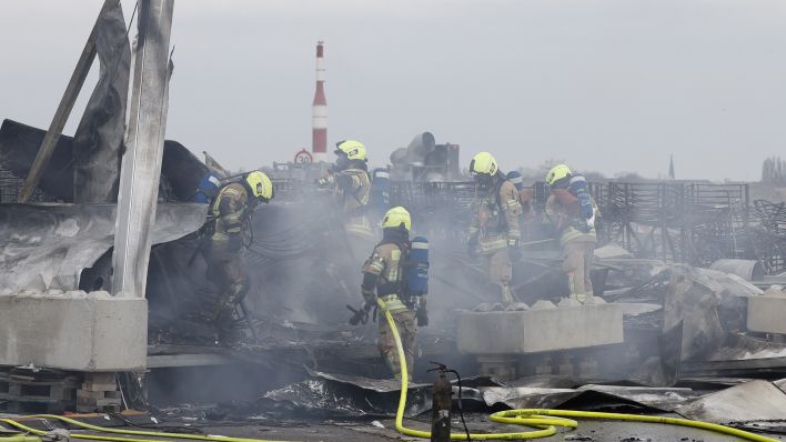 Archivbild: Die Feuerwehr löscht die Brandstelle bei Flüchtlingsunterkunft am ehemaligen Flughafen Tegel. (Quelle: dpa/Koall)
