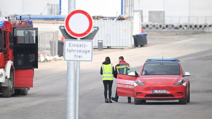 Fahrzeuge der Feuerwehr und Werkfeuerwehr stehen auf dem Gelände der Tesla-Autofabrik in Grünheide, wo die Produktion wegen eines Stromausfalls stillsteht. (Quelle: dpa/Gollnow)