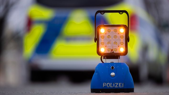 Symbolbild: Ein Warnlicht mit der Auschrift "Polizei" steht auf der Straße vor einem Einsatzfahrzeug der Polizei. (Quelle: dpa/Rolf Vennenbernd)