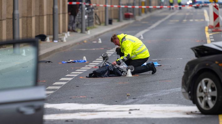 09.03.2024, Berlin: Ein Polizist kniet an einer Unfallstelle in der Leipziger Straße an einem Kinderwagen. (Quelle: dpa/Christophe Gateau)
