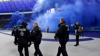 Polizisten vor der in blauen Rauch gehüllten Herthaner Ostkurve. (Foto: IMAGO / Matthias Koch)