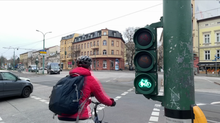 Fahrradfahrer fährt über Kreuzung bei grüner Ampel, rbb24