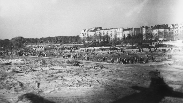Berliner Blockade, 24. Juni 1948 - 12. Mai 1949. - Versorgung ueber die Luftbruecke: Berliner verfolgen Starts und Landungen der Flugzeuge auf dem Flughafen Tempelhof, Foto aus dem Oktober 1948 (Quelle: dpa / Tony Vaccaro).