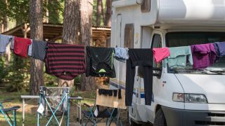 Wäsche hängt auf einer Leine vor einem Wohnmobil auf dem Naturcampingplatz am Springsee, Archivbild (Quelle: DPA/Patrick Pleul)