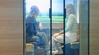 Archivbild: Zwei Mitarbeiterinnen der Deutschen Bahn sitzen in einem Zweierabteil, welches auf der Messe der Deutschen Bahn "Mobilität erleben" ausgestellt ist am 17.04.2024.(Quelle: dpa/Annette Riedl)