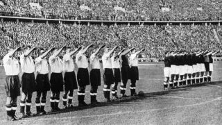 Die Nationalmannschaften von England (vorne) und Deutschland (hinten) stehen auf dem Rasen des Olympiastadions aufgereiht und zeigen den sogenannten "Hitler-Gruß". Bild: imago-images/Heritage Images