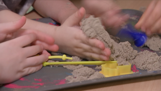 Kinderhände spielen mit Sand, 2024