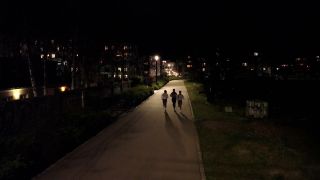 Drei Frauen laufen im Dunkeln durch Berlin.