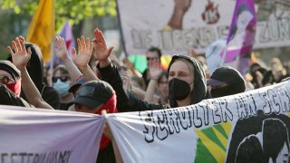 Teilnehmer der "Revolutionären 1. Mai-Demonstration" halten am 01.05.2024 Banner. (Quelle: dpa/Hannes Albert)