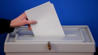 Eine Frau wirft einen Stimmzettel für die Europawahl in eine Wahlurne. (Quelle: dpa/Jan Woitas)