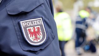 Symbolbild: Wappen der Polizei Brandenburg an der Polizeiuniform. (Quelle: imago images/Gabsch)