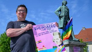 Archivbild: Der Politiker Freke Over steht am Denkmal von Kronprinz Friedrich, das mit einer Regenbogenfahne geschmückt ist. Er gehört zu den Organisatoren des ersten "Christopher Street Day" (CSD) in Rheinsberg. (Quelle: dpa/Kalaene)