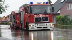 Archivbild: Die Feuerwehr steht in Brandenburg in den überfluteten Straßen. (Quelle: dpa/Zinken)