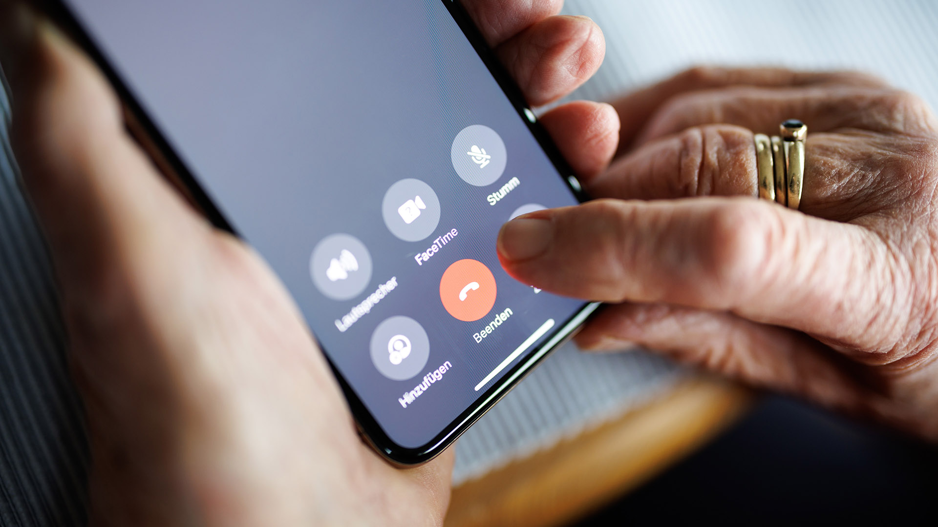 Symbolbild: Eine über 90-jährige Dame drückt auf ihrem Smartphone während eines Telefongesprächs auf die rote Schaltfläche zum Beenden des Anrufs. (Quelle: dpa/Balk)