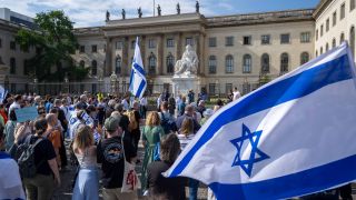 Teilnehmer stehen mit israelischen Fahnen bei einer Kundgebung von Fridays for Israel vor der Humboldt-Universität. (Bild: dpa-news/Christophe Gateau)
