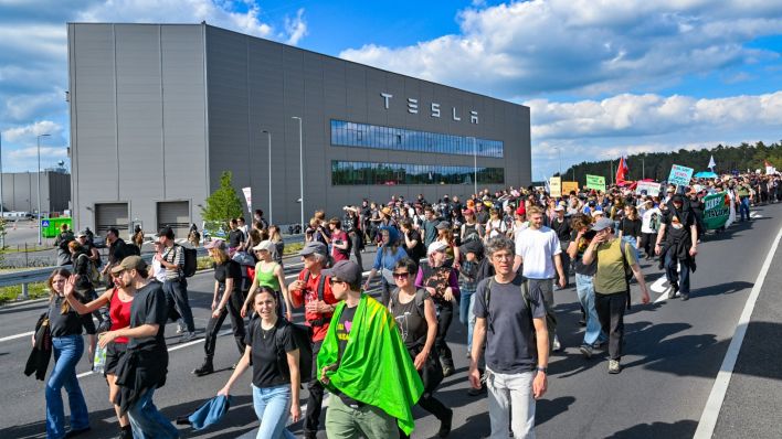 Brandenburg, Grünheide: Teilnehmer einer Protestveranstaltung gehen zum Werk von Tesla. Nach teils heftigen Auseinandersetzungen am 10.05.2024 am Tesla-Werksgelände in Grünheide bei Berlin stellt laufen derzeit neue Proteste gegen das US-Unternehmen.