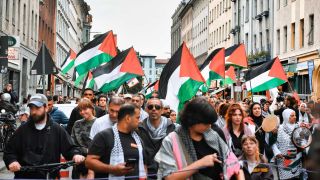 Berlin: Teilnehmer gehen mit palästinensischen Fahnen bei einer pro-palästinensische Demonstration über eine Straße in Kreuzberg am 29. Mai (Bild: Paul Zinken/dpa)