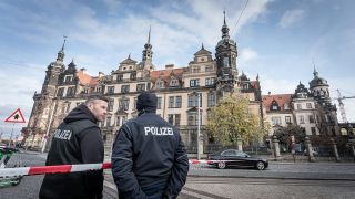 Polizeibeamte stehen nach dem Einbruch ins Grüne Gewölbe in Dresden an einem Polizeiabsperrband vor dem Gebäude. (Quelle: imago-images/Max Stein)
