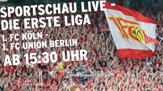 Fans des 1. FC Union Berlin mit großer Fahne auf Tribüne, darauf Text: "Sportschau live - Die erste Liga, 1. FC Köln - 1. FC Union Berlin, ab 15:30 Uhr" (Bild: Imago Images/Picture Point LE)