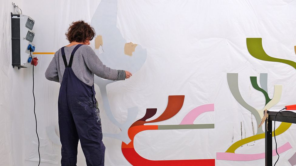 Anna Ingerfurth erarbeitet im Januar 2024 in der Stuttgarter Wagenhalle ihr Wandgemälde, dass als „Kunst am Bau“ in der Grundschule am Blockdammweg in Berlin-Karlshorst montiert werden wird. (Quelle: rbb24/Caroline Winkler)