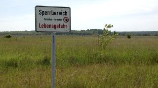 Ein Betreten-Verboten-Schild warnt vor einem inaktiven Tagebau in Brandenburg, Deutschland.