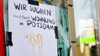 Symbolbild:Mit einem Zettel «Wir suchen eine 2-Raum-Wohnung in Potsdam», der im Stadtzentrum angebracht ist, versucht ein Paar, eine Wohnung zu finden.(Quelle:picture alliance/dpa/J.Kalaene)