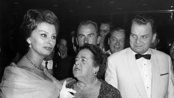 Die italienische Schauspielerin Sophia Loren, die US-amerikanische Journalistin Elsa Maxwell und der Festspielleiter Dr. Alfred Bauer unterhalten sich auf dem Fest im Palais am Funkturm am 4. Juli 1959 während der IX. Internationalen Filmfestspiele in Berlin (Quelle: dpa/Konrad Giehr)